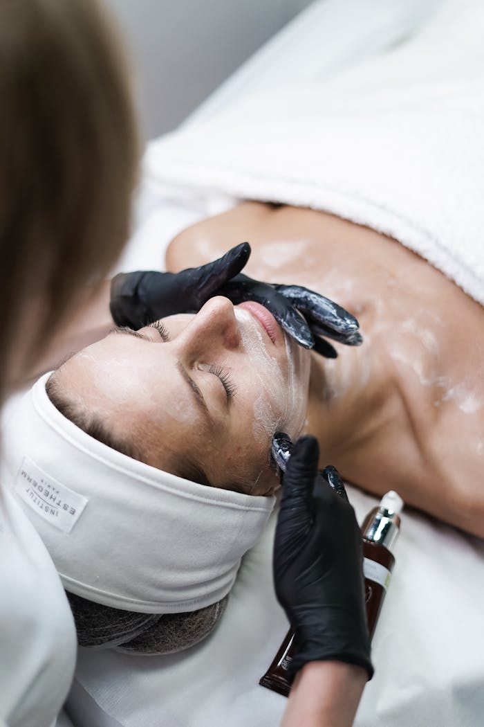 A relaxing skincare session with a woman receiving a facial treatment at a spa.